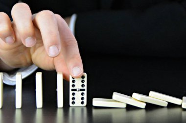 Domino bir başka mükemmel işleyen zincir reaksiyonu bir rahatsızlık faktörü inceleyerek genç bir işadamı bir elin yakın çekim-liderlik kararlarının karmaşıklığı sembolik 