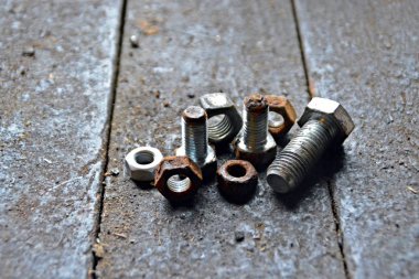 Çeşitli vidalar arkasında pozlama ile ahşap bir tezgah üzerinde yatıyor 