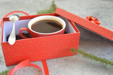 Bir fincan kahve dolu içinde kahve çekirdekleri ile bir Noel hediye kutusunda - kahve noel için bir tedavi ve hediye olarak güzel paketlenmiş 