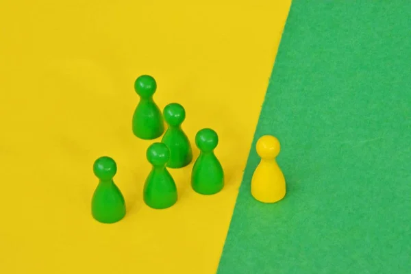 team of wooden game characters of a board game face each other and are greeted by the respective oppositely colored background