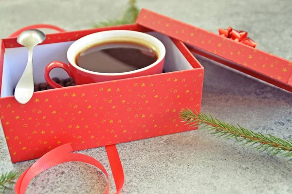 Bir fincan kahve dolu içinde kahve çekirdekleri ile bir Noel hediye kutusunda - kahve noel için bir tedavi ve hediye olarak güzel paketlenmiş 