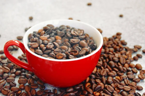 Červený Pohár Plný Kávových Bobů Stojí Šedivém Trávníku Jinými Kávovou — Stock fotografie
