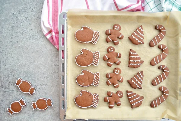 Home-baked gingerbread biscuits in a variety of shapes and decorated with white sugar mass lie on a kitchen surface with space for text or elements - Gingerbread frame for Christmas