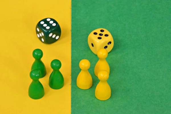 team of wooden game characters of a board game face each other and are greeted by the respective oppositely colored background