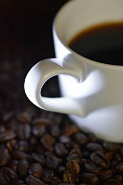 Kahve için aşk tasvir gölge ile minimalist kavramı-kahve bir fincan kolu gölge ve hangi kahve çekirdekleri üzerinde duruyor ışık gölgesinde bir kalp gibi görünüyor 