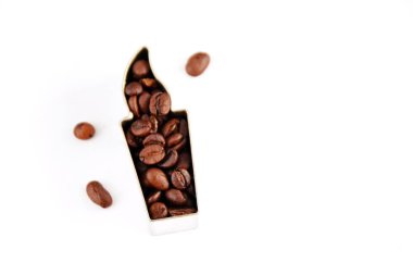 Metin veya diğer unsurlar için yer ile beyaz bir arka plan önünde kahve çekirdekleri ile dolu çerezleri için bir çerez kesici - noel şekli ve kahve çekirdekleri ile kavram 