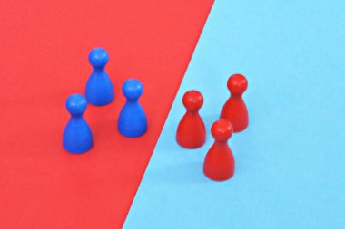 Bir masa oyunu ahşap oyun karakterleri bir kırmızı ve mavi bir takım birbirlerine karşı karşıya ve ilgili karşıt renkli arka plan tarafından karşılandı - sınırları ve farklılıkları kavramı 