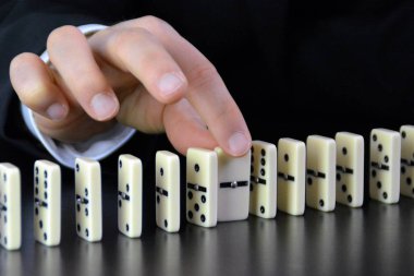Domino bir başka mükemmel işleyen zincir reaksiyonu bir rahatsızlık faktörü inceleyerek genç bir işadamı bir elin yakın çekim-liderlik kararlarının karmaşıklığı sembolik 