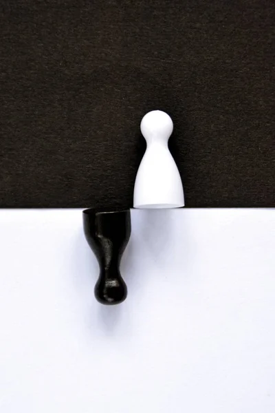 Ένα Μαύρο Πιόνι Στέκεται Μπροστά Από Ένα Λευκό Φόντο Και — Φωτογραφία Αρχείου