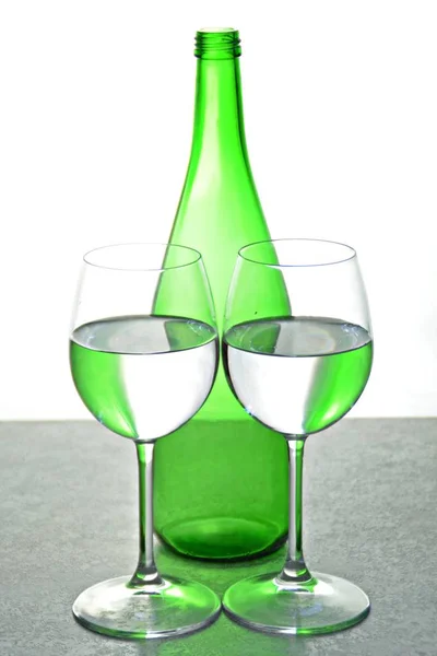 Два Келихи Водою Відображають Зелену Пляшку Вина Задньому Плані Протилежному — стокове фото