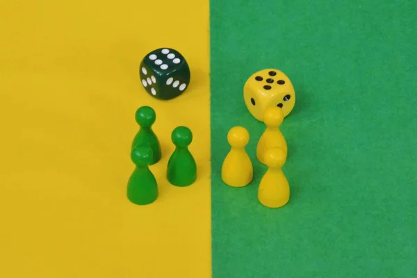 team of wooden game characters of a board game face each other and are greeted by the respective oppositely colored background