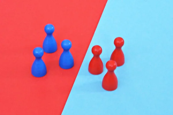 Bir masa oyunu ahşap oyun karakterleri bir kırmızı ve mavi bir takım birbirlerine karşı karşıya ve ilgili karşıt renkli arka plan tarafından karşılandı - sınırları ve farklılıkları kavramı 