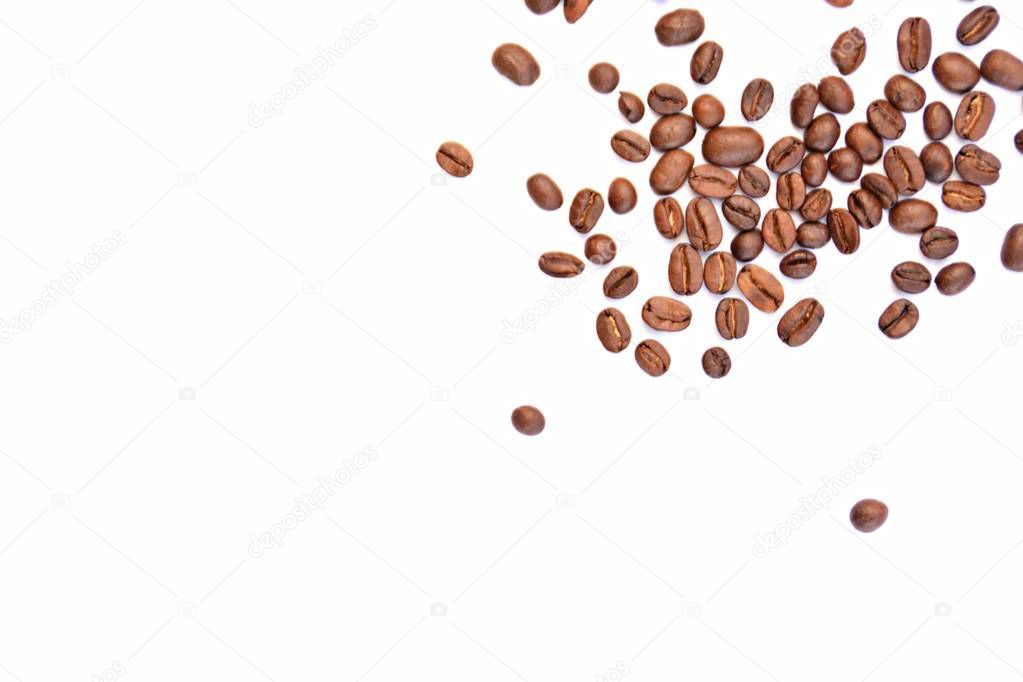 Coffee beans lie on a white surface and protrude into the picture - white background with coffee beans on it and space for text or other elements 