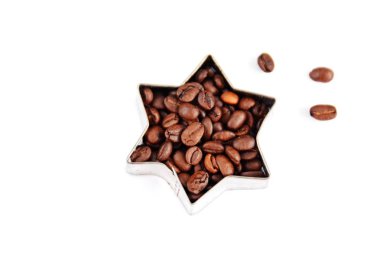 Metin veya diğer unsurlar için yer ile beyaz bir arka plan önünde kahve çekirdekleri ile dolu çerezleri için bir çerez kesici - noel şekli ve kahve çekirdekleri ile kavram 