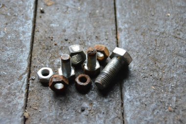 Çeşitli vidalar arkasında pozlama ile ahşap bir tezgah üzerinde yatıyor 