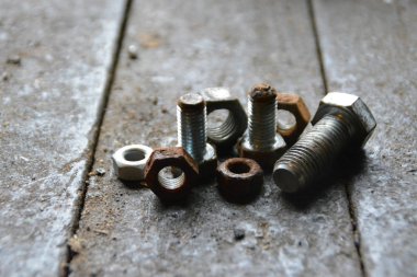 Çeşitli vidalar arkasında pozlama ile ahşap bir tezgah üzerinde yatıyor 