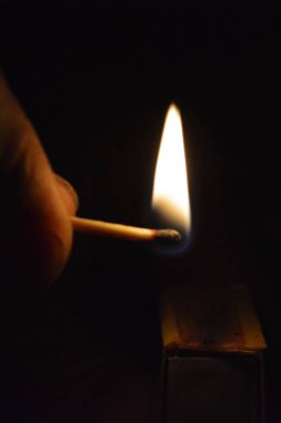 Bir kibrit kutusu üzerinde karanlıkta bir maç ateşleyici-gece bir aydınlatma maç yakın çekim-maç gece yaktı 