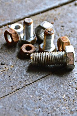 Çeşitli vidalar arkasında pozlama ile ahşap bir tezgah üzerinde yatıyor 