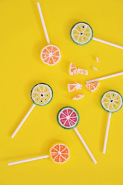 Renkli bir arka planda kireç ve limon veya karpuz gibi meyve görünümü ile lezzetli tatlı lolipop