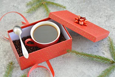 Bir fincan kahve dolu içinde kahve çekirdekleri ile bir Noel hediye kutusunda - kahve noel için bir tedavi ve hediye olarak güzel paketlenmiş 