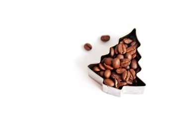 Metin veya diğer unsurlar için yer ile beyaz bir arka plan önünde kahve çekirdekleri ile dolu çerezleri için bir çerez kesici - noel şekli ve kahve çekirdekleri ile kavram 