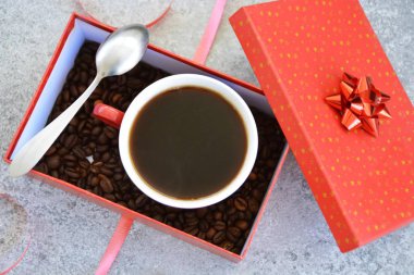 Bir fincan kahve dolu içinde kahve çekirdekleri ile bir Noel hediye kutusunda - kahve noel için bir tedavi ve hediye olarak güzel paketlenmiş 