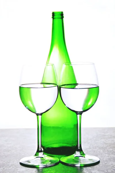 Dois Copos Vinho Com Água Refletem Garrafa Vinho Verde Fundo — Fotografia de Stock