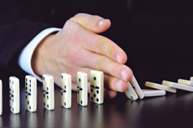 Domino bir başka mükemmel işleyen zincir reaksiyonu bir rahatsızlık faktörü inceleyerek genç bir işadamı bir elin yakın çekim-liderlik kararlarının karmaşıklığı sembolik 