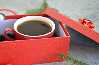 Bir fincan kahve dolu içinde kahve çekirdekleri ile bir Noel hediye kutusunda - kahve noel için bir tedavi ve hediye olarak güzel paketlenmiş 