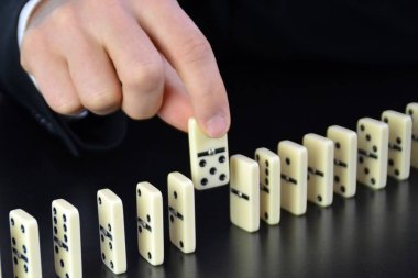 Domino bir başka mükemmel işleyen zincir reaksiyonu bir rahatsızlık faktörü inceleyerek genç bir işadamı bir elin yakın çekim-liderlik kararlarının karmaşıklığı sembolik 