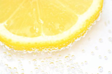 Beyaz arka planda gazlı suda bir kireç ile bir kireç kabuğu üzerinde hava kabarcıkları formu-su kireç yakın çekim