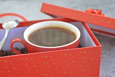 Bir fincan kahve dolu içinde kahve çekirdekleri ile bir Noel hediye kutusunda - kahve noel için bir tedavi ve hediye olarak güzel paketlenmiş 