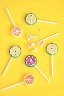 Renkli bir arka planda kireç ve limon veya karpuz gibi meyve görünümü ile lezzetli tatlı lolipop