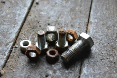 Çeşitli vidalar arkasında pozlama ile ahşap bir tezgah üzerinde yatıyor 