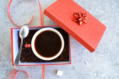 Bir fincan kahve dolu içinde kahve çekirdekleri ile bir Noel hediye kutusunda - kahve noel için bir tedavi ve hediye olarak güzel paketlenmiş 