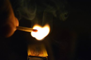Bir kibrit kutusu üzerinde karanlıkta bir maç ateşleyici-gece bir aydınlatma maç yakın çekim-maç gece yaktı 