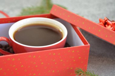 Bir fincan kahve dolu içinde kahve çekirdekleri ile bir Noel hediye kutusunda - kahve noel için bir tedavi ve hediye olarak güzel paketlenmiş 