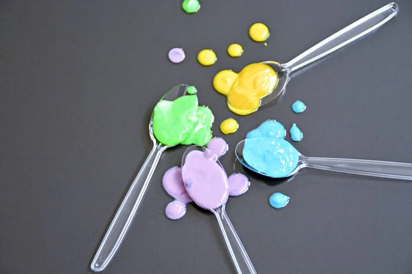 Transparent Spoons Different Drops Paint Top Plain Background Plastic Spoon — Stock Photo, Image