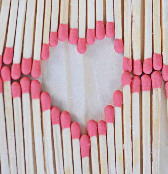 The head of many matches forms the shape of a heart - close-up