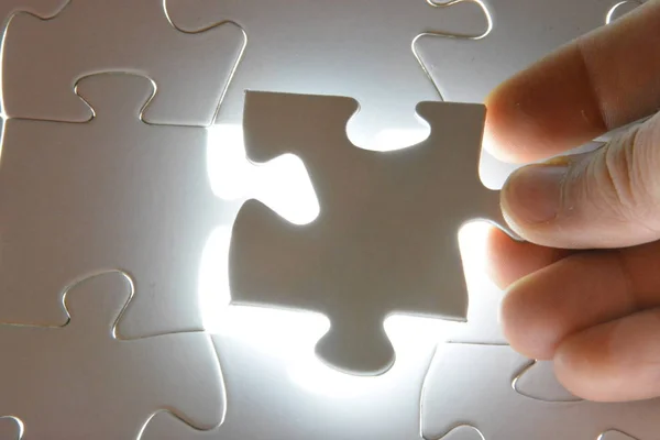 Nahaufnahme Einer Hand Die Ein Weißes Puzzleteil Einem Gesamtpuzzle Zusammenfügt — Stockfoto