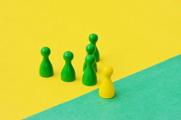 team of wooden game characters of a board game face each other and are greeted by the respective oppositely colored background