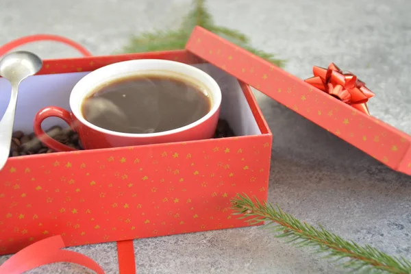 Bir fincan kahve dolu içinde kahve çekirdekleri ile bir Noel hediye kutusunda - kahve noel için bir tedavi ve hediye olarak güzel paketlenmiş 