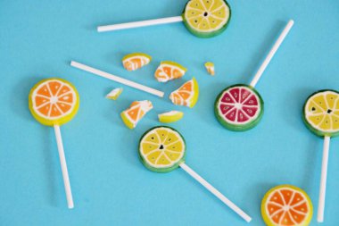 Renkli bir arka planda kireç ve limon veya karpuz gibi meyve görünümü ile lezzetli tatlı lolipop