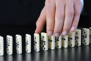 Domino bir başka mükemmel işleyen zincir reaksiyonu bir rahatsızlık faktörü inceleyerek genç bir işadamı bir elin yakın çekim-liderlik kararlarının karmaşıklığı sembolik 