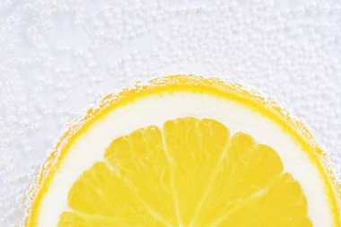 Taze turuncu bir dilim yukarıdan aydınlatılmış beyaz parlak bir arka plan üzerinde yatıyor - taze turuncu ile kavram 