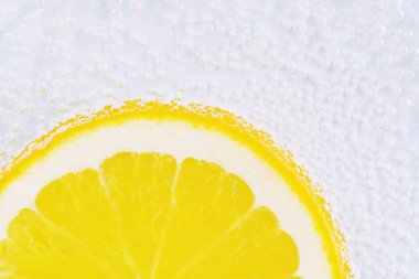 Taze turuncu bir dilim yukarıdan aydınlatılmış beyaz parlak bir arka plan üzerinde yatıyor - taze turuncu ile kavram 