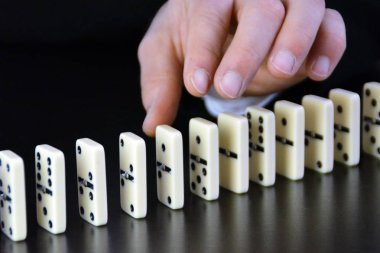 Domino bir başka mükemmel işleyen zincir reaksiyonu bir rahatsızlık faktörü inceleyerek genç bir işadamı bir elin yakın çekim-liderlik kararlarının karmaşıklığı sembolik 