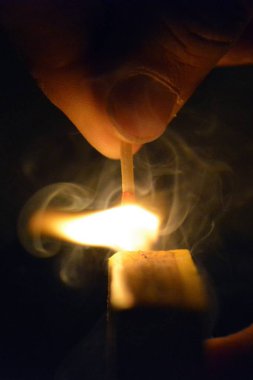 Bir kibrit kutusu üzerinde karanlıkta bir maç ateşleyici-gece bir aydınlatma maç yakın çekim-maç gece yaktı 