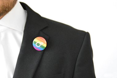 20'li yaşlarının ortasında bir adam takım ceketinde transseksüel sembolü olan bir düğme takıyor - Çalışma Hayatında Kabul ve Hoşgörü Kavramı