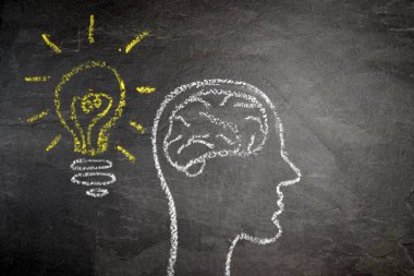 Düşünce süreci için bir kavramı ve sembolü olarak karanlık bir taş yüzey üzerinde tebeşir ile çizilmiş bir kafa silüeti ve yaratıcılık ve problem çözme unfolding için beyin fırtınası 